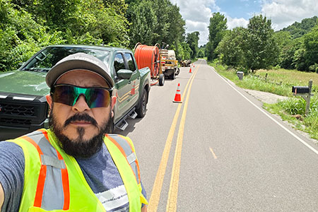Bonerges Claudino on a roadway performing utility work with his crew and a Vermeer drill