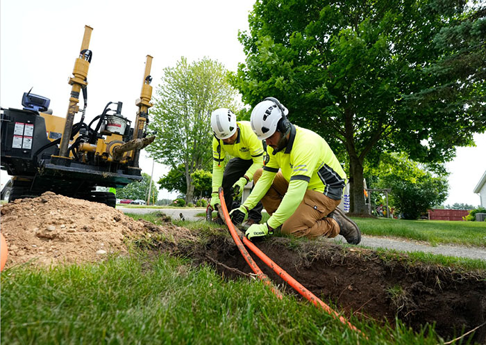 Two HDD crew members working on a bore with a Vermeer horizontal directional drill