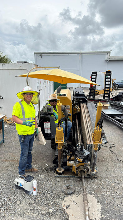Manuel Aleon poses with an HDD crew member while he operates a Vermeer directional drill