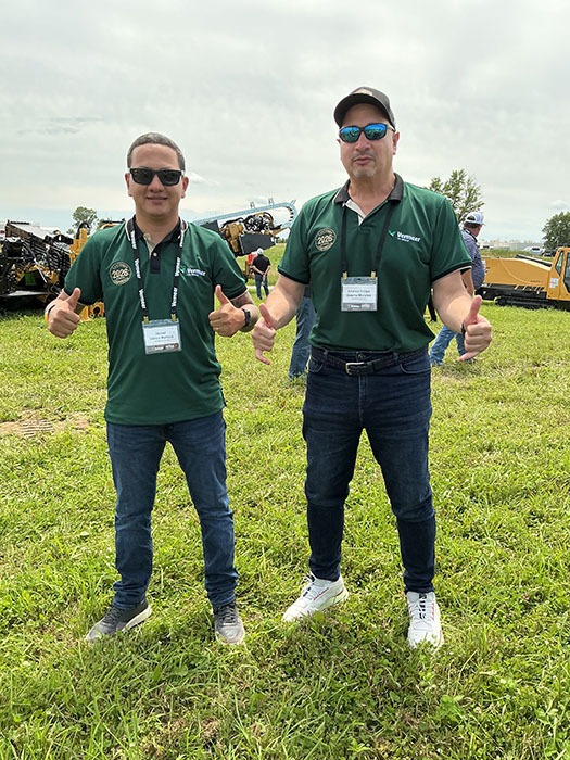 Andres Felipe Guerra Morales and a colleague standing in front of Vermeer directional drills holding up a thumbs up
